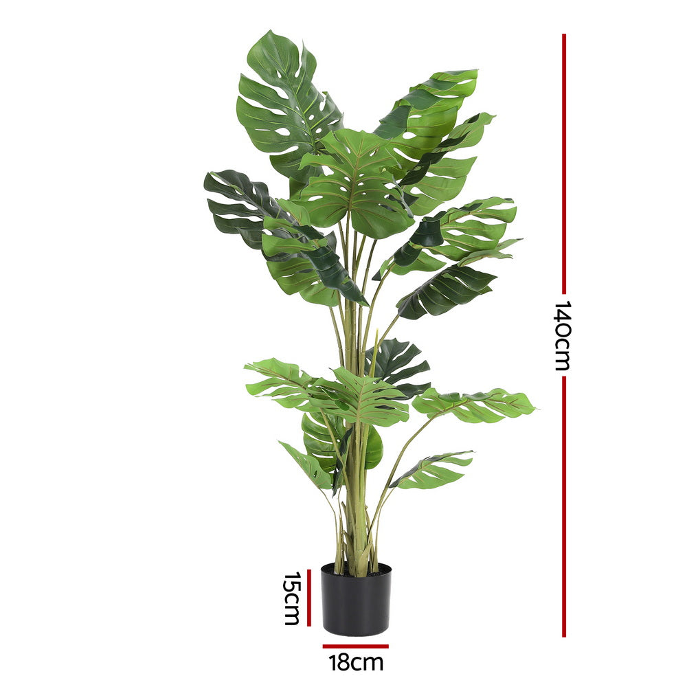 Artificial monstera plant with dimensions indicated on a white background