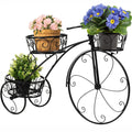 Black iron tricycle plant stand with faux greenery, designed for home and garden decor, by Faux Flora.