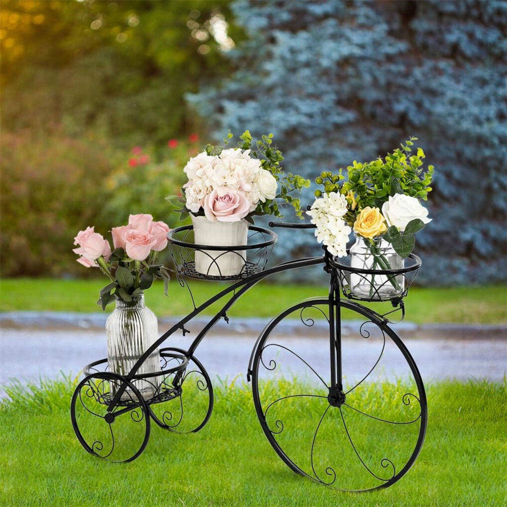 Black iron tricycle plant stand with faux plant, decorative home and garden accessory for displaying artificial plants.