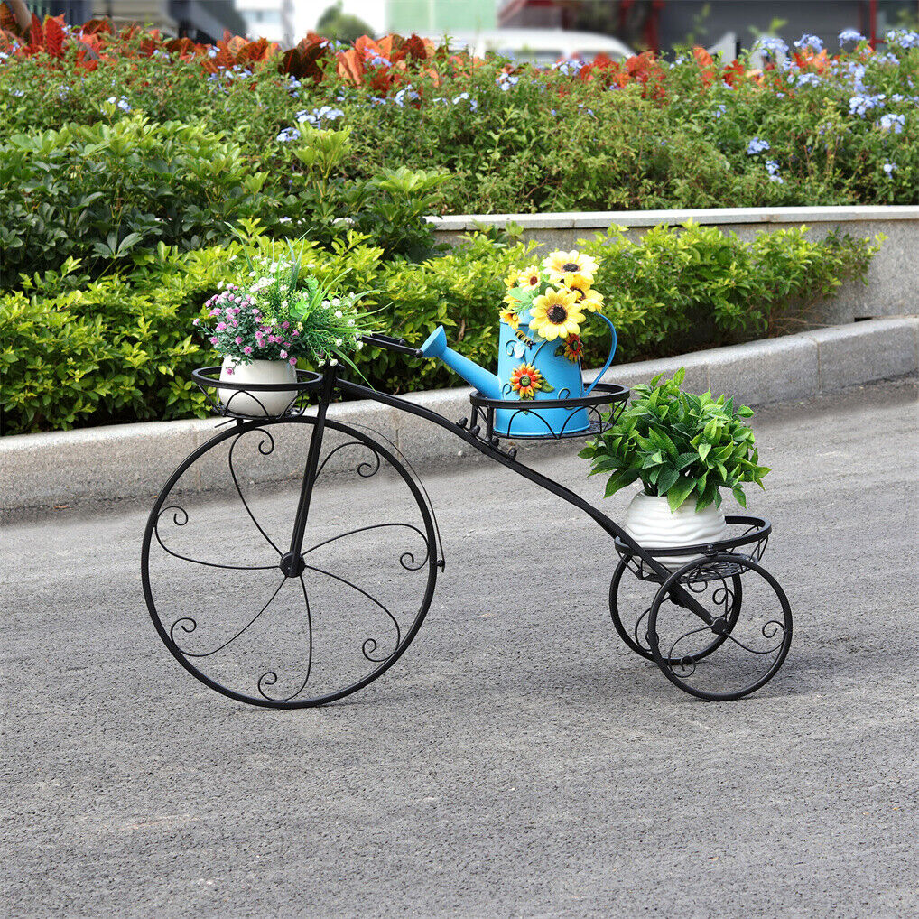 Black iron tricycle plant stand with faux plant arrangement for home and garden decor.