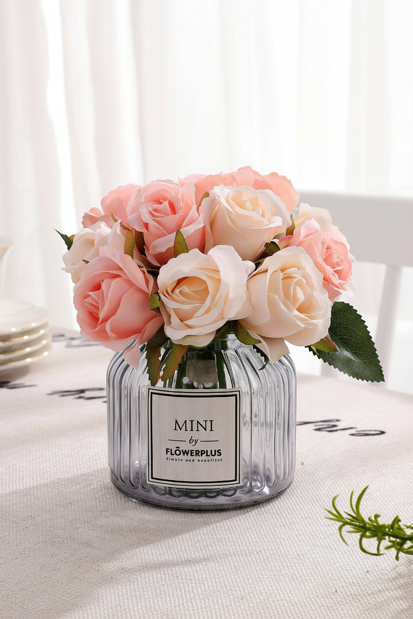 Glass vase with pink and white flowers on a table