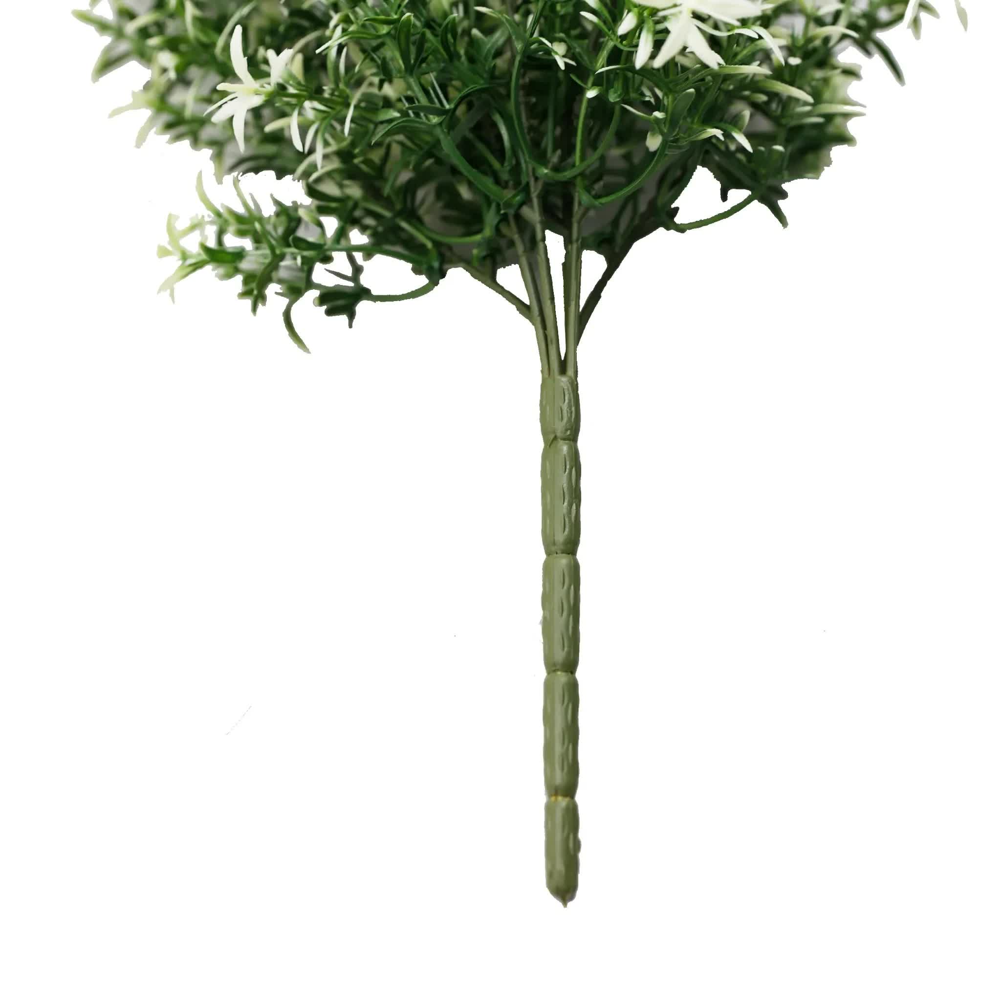 Artificial green plant with white flowers on a white background
