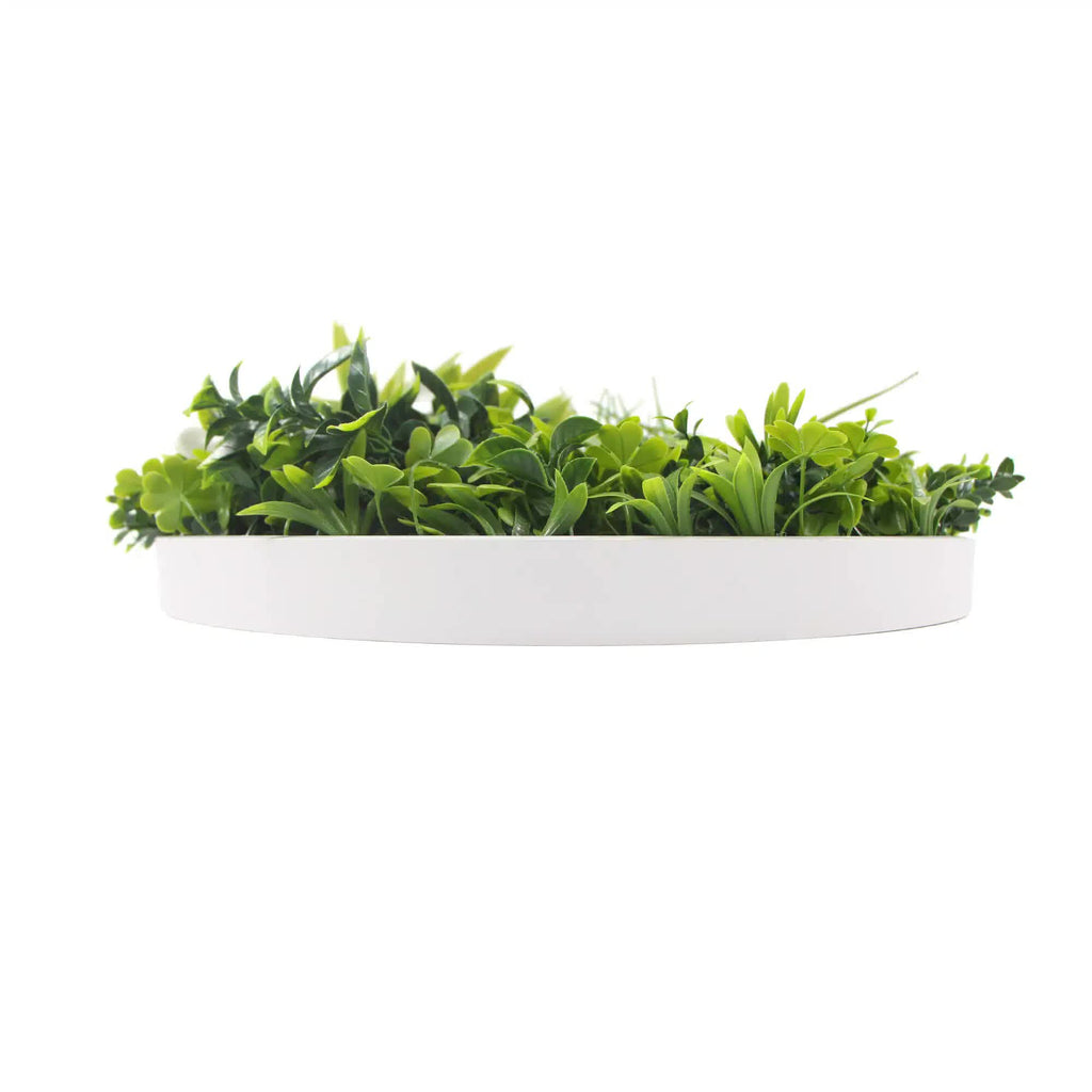 White artificial green wall disc with flowering plants by Faux Flora, UV resistant, 75cm diameter, mounted on a white frame.