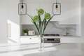 Kitchen – stems in clear glass vase on marble island